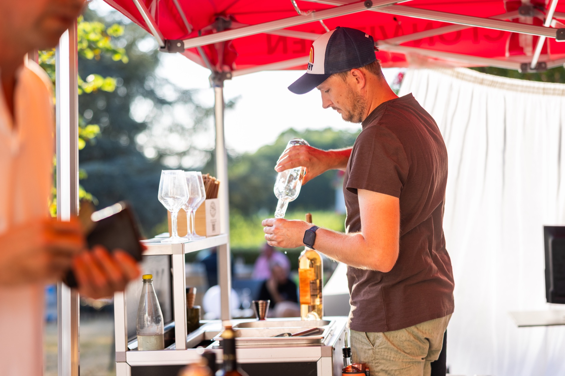 Bartender pouring at the outdoor bar in late afternoon light
