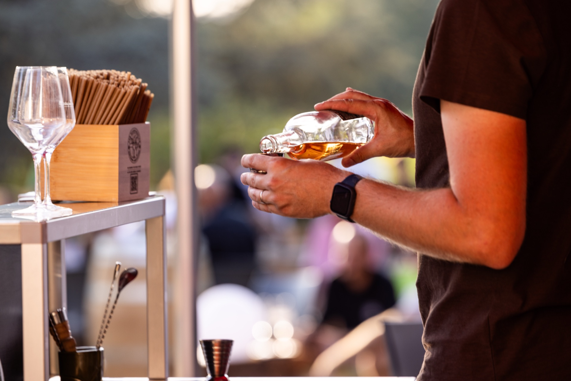 Close pour into a glass, straws and stemware stacked alongside
