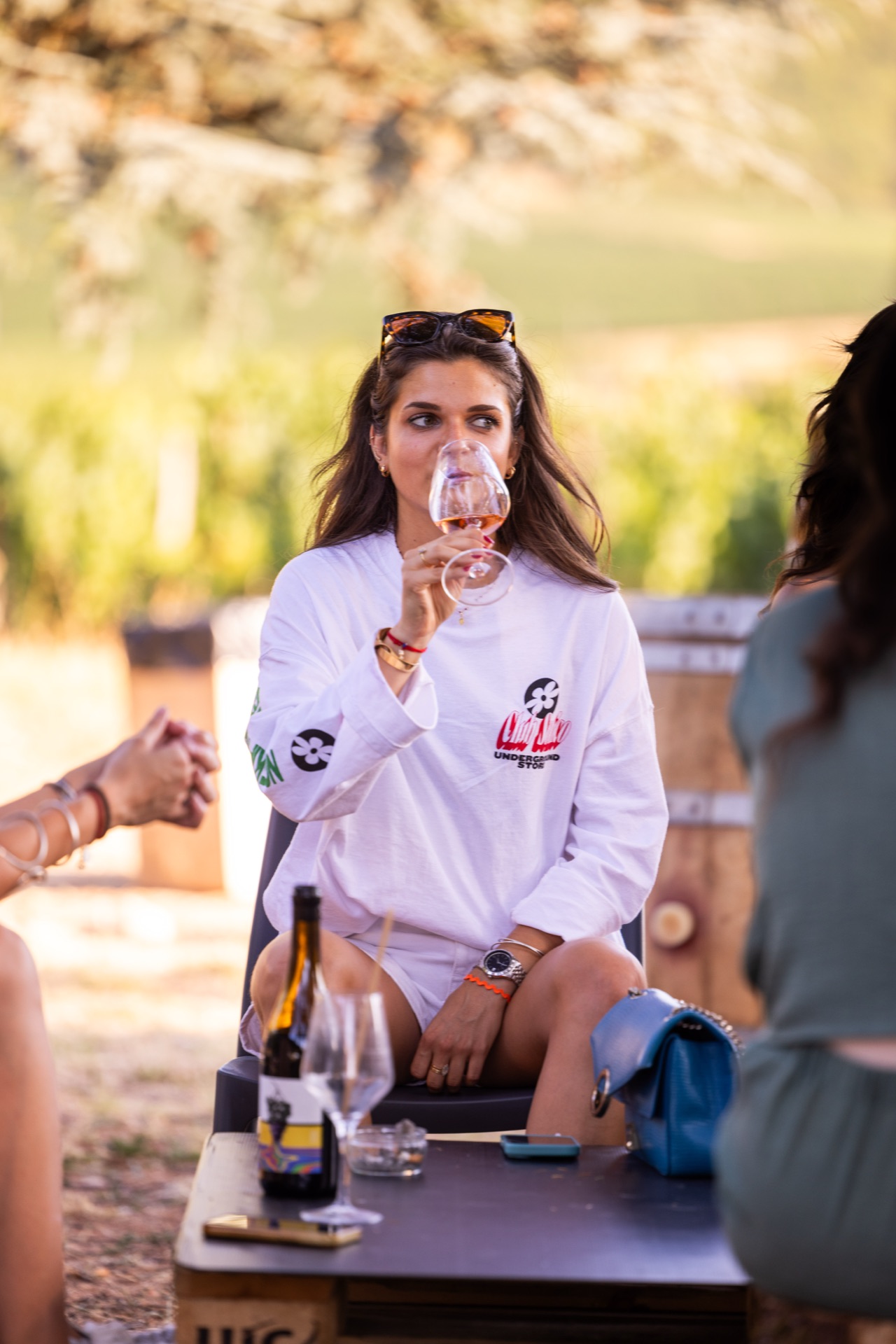 A guest tasting rosé with the vine rows behind her