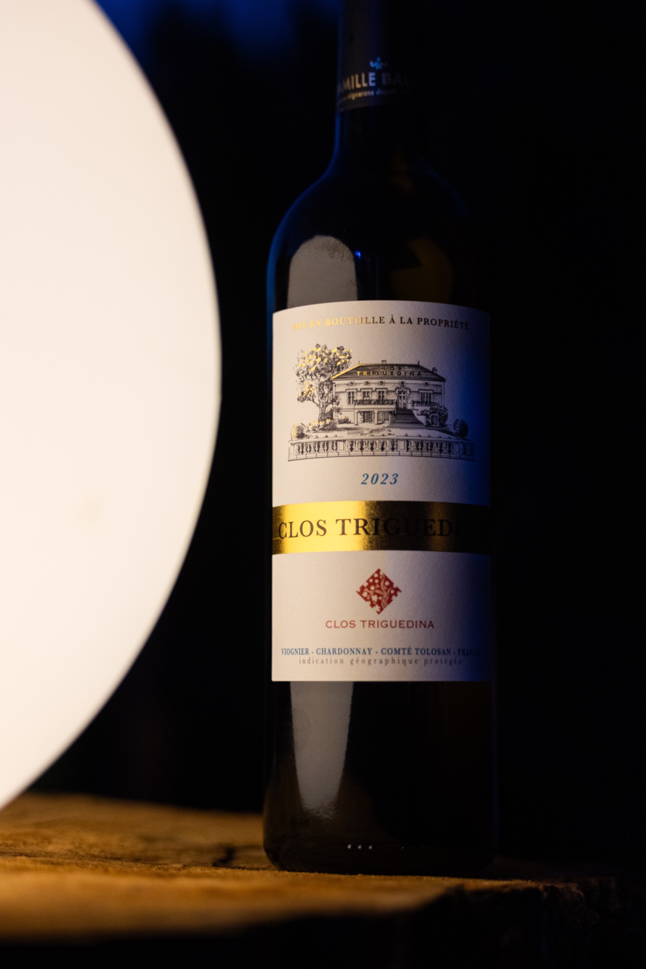 Clos Triguedina bottle lit against a dark ground