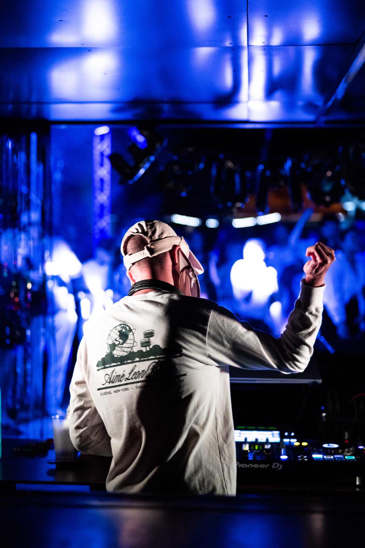 The DJ shot from behind under blue stage light