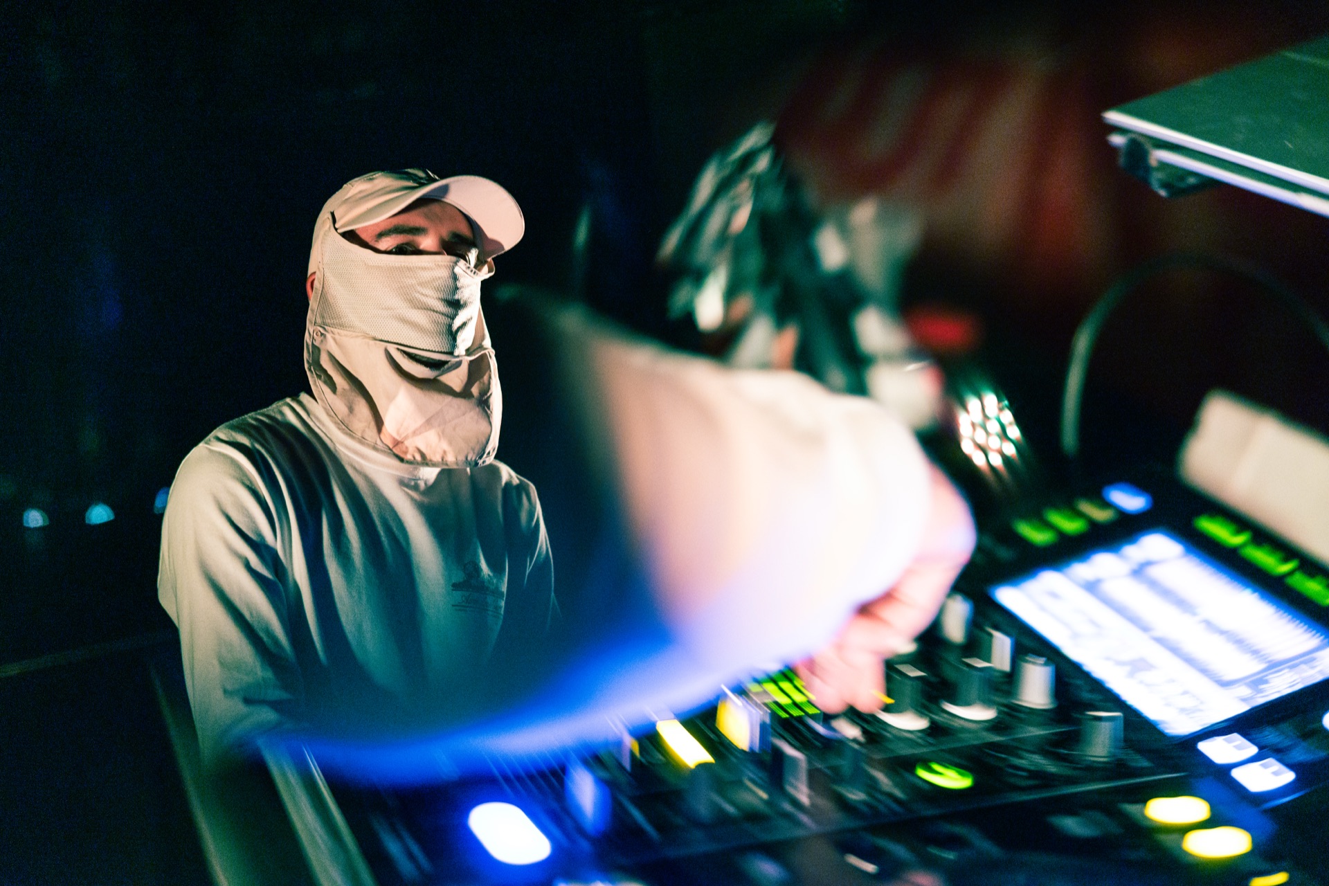 The DJ working the mixer, hand blurred through the frame