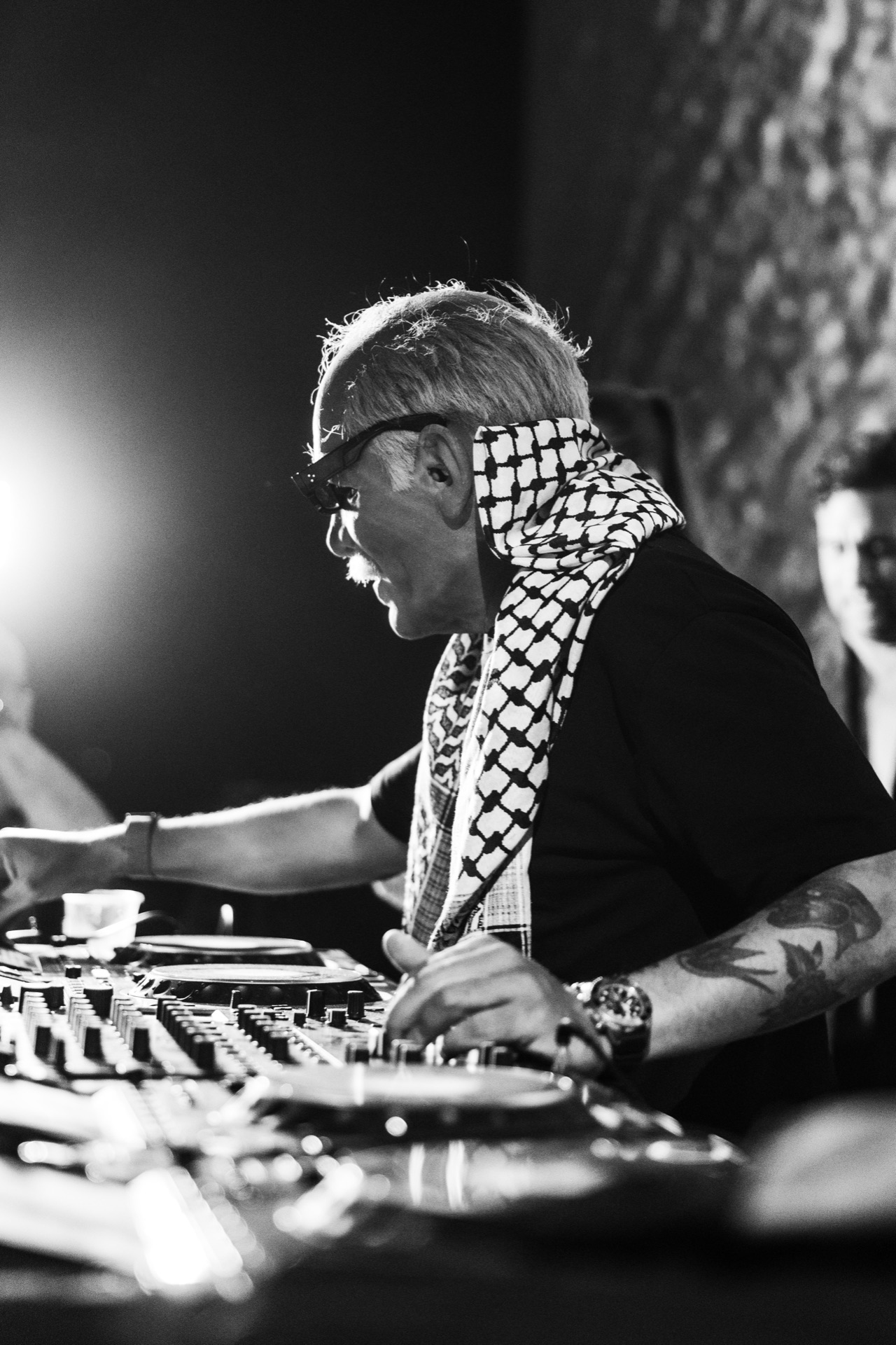 Black and white frame of Doctor Alphonso mid-set, keffiyeh at his shoulders