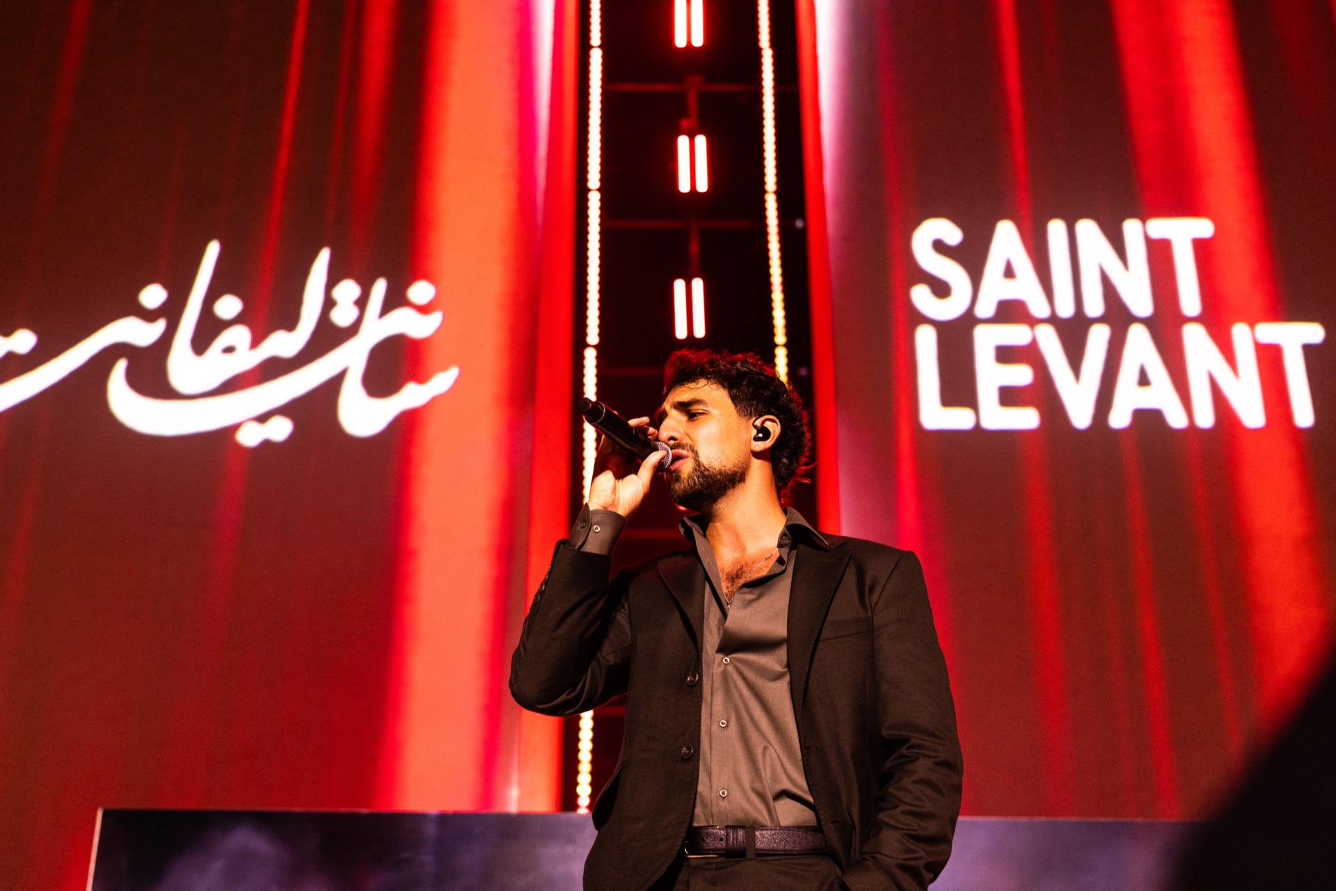 His name on the wall in Arabic and Latin script as he sings
