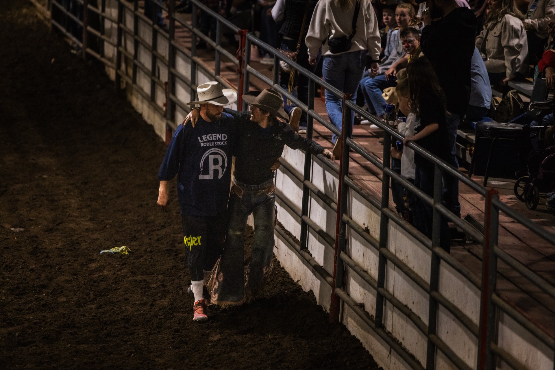 Two figures make their way back along the rail in the dark after a ride