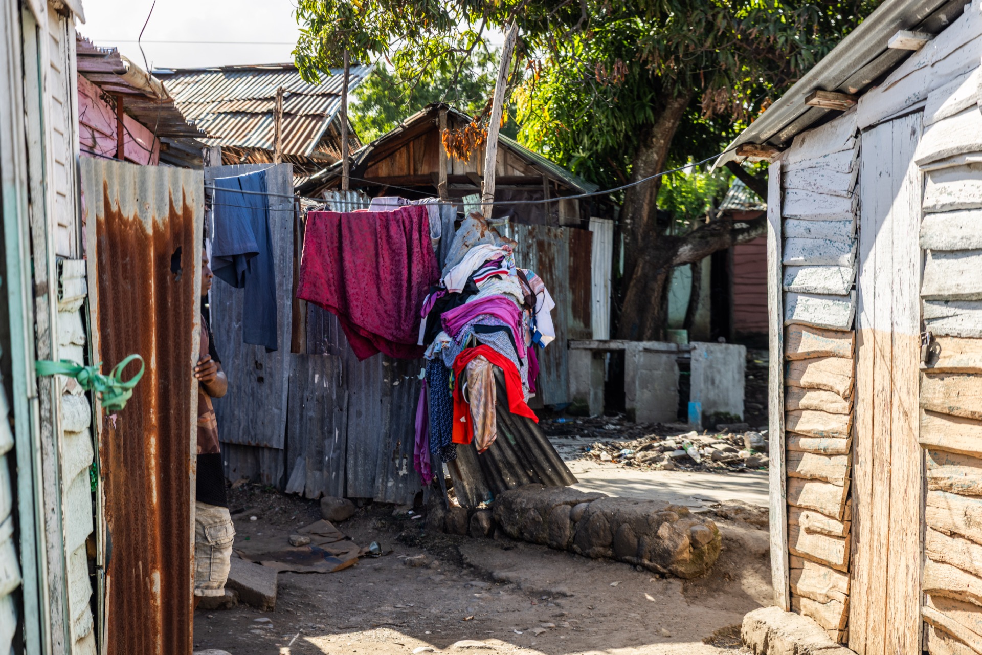 Laundry hung to dry in a narrow lane between corrugated-metal houses